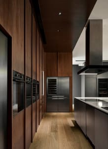 Modern kitchen with wooden cabinets, stainless steel appliances, and a white countertop.