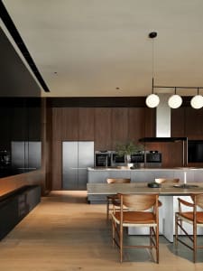 A modern kitchen featuring wooden cabinets, stainless steel appliances, and a concrete countertop.