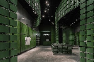A retail shop interior with green tiled walls and floors.