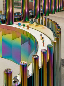 A retail counter featuring a metallic foil design in a curved, rainbow-colored metal structure.