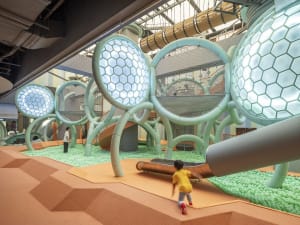 A modern playground featuring honeycomb-shaped structures and a slide for children.
