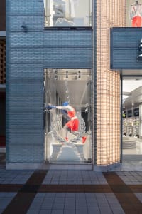 Modern retail storefront featuring concrete, glass, and metal materials.