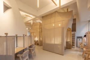 A workspace with fabric-walled partitions and wooden furniture.