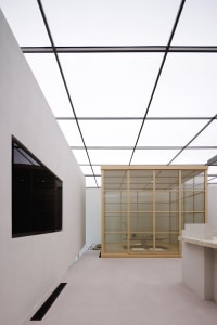 A modern office space featuring glass floor and ceiling panels.
