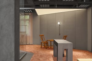 A minimalist office space featuring modern concrete and wooden furniture.