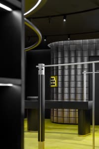 A sleek, modern retail display featuring metallic surfaces, glass panels, and illuminated neon elements.