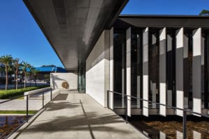 Modern building facade with concrete panels and large windows.