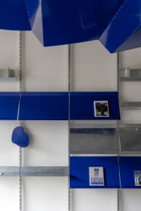 Modern interior design featuring blue metal panels with shelving
