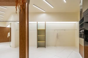 Modern closet with white-paneled walls and yellow shelves.