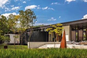 A modern exterior featuring black glass, concrete, and metal elements.