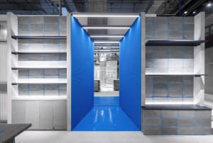 Industrial storefront with blue panels and concrete shelving units.