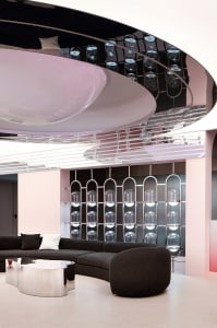 A modern living room featuring a mirror ceiling and metallic furniture.