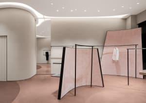 Modern minimalist fashion retail store with pink ceramic powder flooring and pink curtains.
