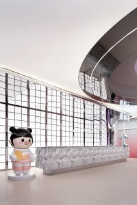 Modern minimalist retail space featuring metallic finishes and white grid windows.