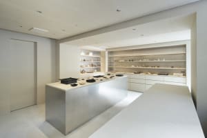 Modern display case featuring white glass elements and various ceramic products.