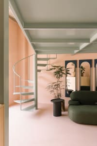 A modern interior space featuring spiral stairs made of steel and wooden accents.