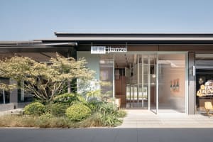 Modern retail storefront with glass walls and concrete elements.