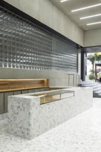 A modern restaurant counter with a marble facade and glass display case.