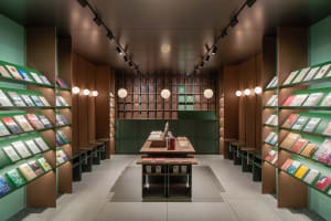 A modern bookstore with wooden shelves and green wall panels
