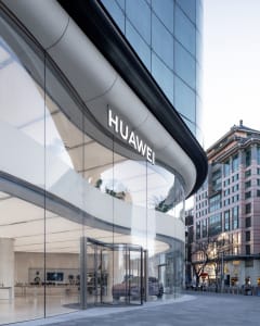 A contemporary glass storefront with a Huawei sign.