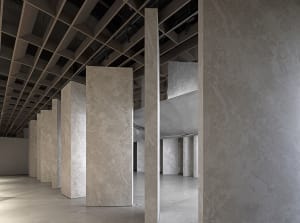 Modern exhibition gallery space featuring granite columns
