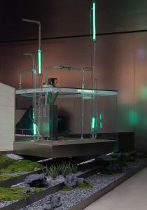 An industrial installation featuring glass tubes and pipes connected to a mechanical device in a modern, minimalist setting.