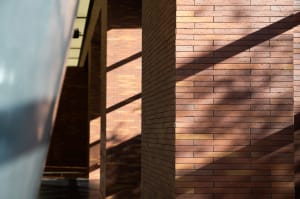 A close-up of modern brick walls with sunlight casting shadows, showcasing contemporary architectural design.