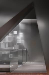 Modern elevator room with glass walls and geometric lighting fixtures.