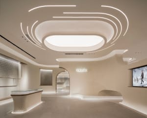 A minimalist retail storefront featuring a concrete ceiling and glass walls.
