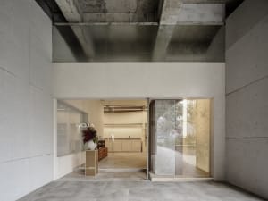 Modern storefront with concrete exterior and large glass panels.