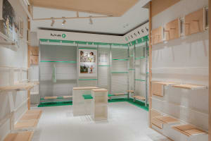 A modern retail store display featuring cork paneling walls and shelves.