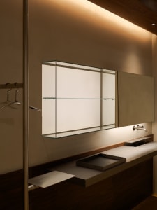 Modern minimalist bathroom with concrete floor, glass shelves, and wooden vanity.