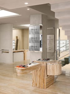 A modern optical retail store with a marble interior, featuring eyewear displays and a sleek, contemporary design.
