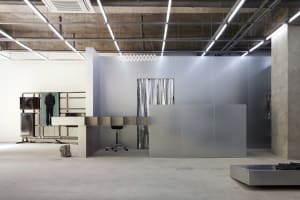 A minimalist storefront with metallic surfaces and frosted glass.