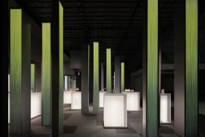 An interior exhibition space featuring modern LED columns and carpeting.