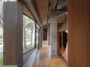 Modern retail store interior featuring industrial design elements such as metallic columns, concrete walls, and wooden accent