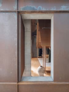 Modern retail storefront with a concrete and wooden facade.
