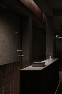 An industrial-style reception counter made of granite with hanging ornaments.