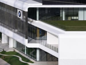 Modern office building with glass walls and metal accents, featuring concrete elements