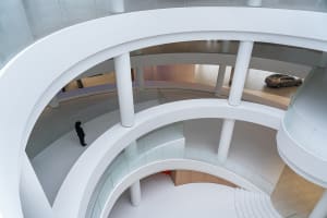Circular architectural design featuring glass walls and white interiors.