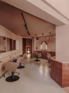 Minimalist salon interior featuring concrete tiles and modern styling.