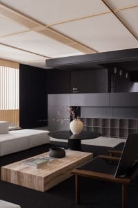 Modern interior design featuring marble coffee table and black chairs with a round black table holding a white vase with cher