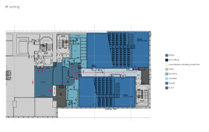 A detailed architectural blueprint of a cinema hall showing the layout, seating arrangement, and functional zones.