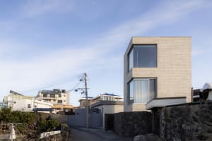 A minimalist brick house with large windows and a sleek design.
