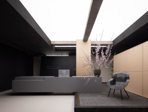 A modern office space with a white concrete floor, minimalist furniture, and a sleek desk.