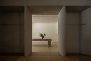 A minimalist closet interior with a concrete bench and floral arrangement.