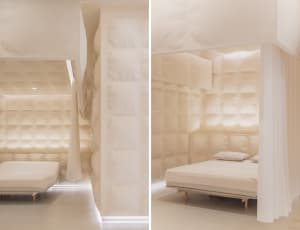 A minimalist bedroom with soft textiles, featuring a bed and a curtain.