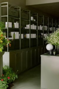 Modern spa retail interior with glass shelves and flowers decor.
