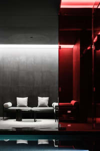 Modern, minimalist spa relaxation room featuring concrete and metal elements.