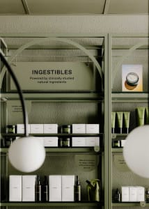 Modern retail interior showcasing cosmetic products on metal shelves with green glass containers.